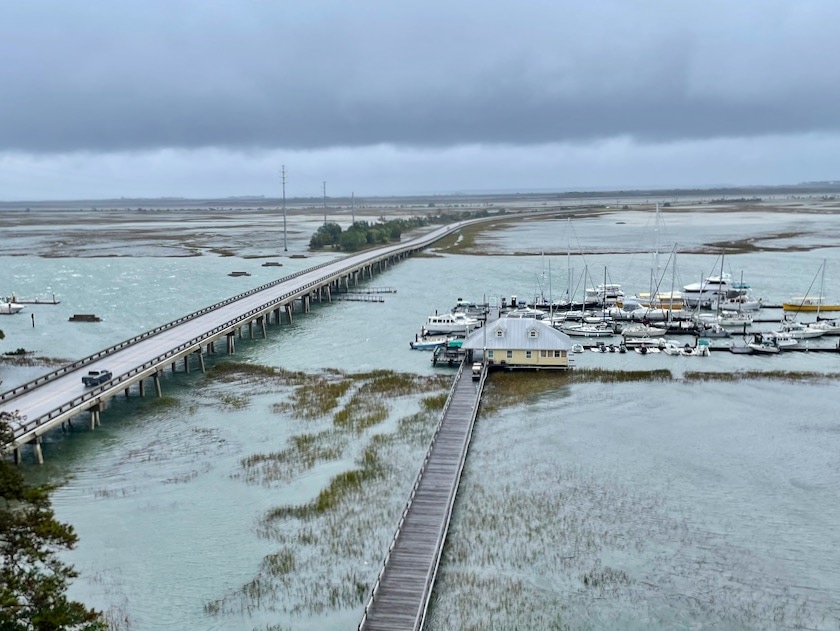 aerial image of marshland with a marina and bridge